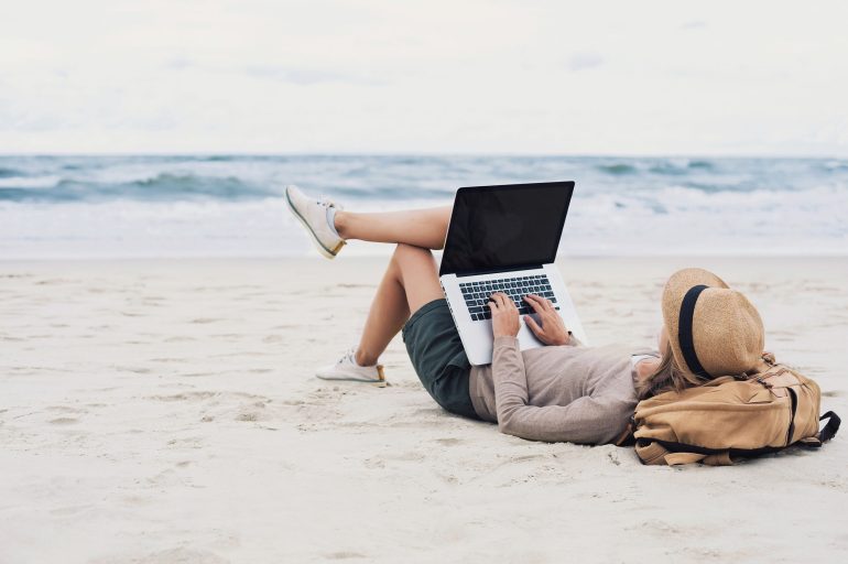 woman on laptop on beach