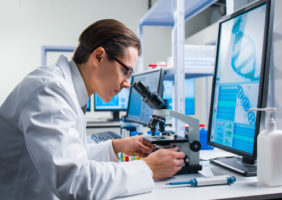 R&D, science, man looking in microscope