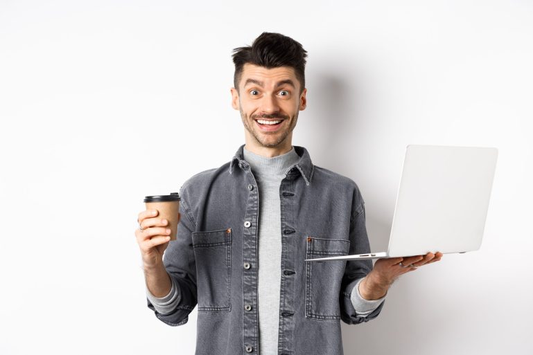 Happy energized guy drinking coffee and working