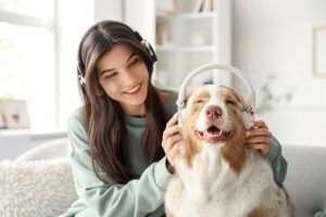 woman with Australian Shepherd dog in headphones