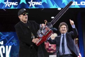 Elon Musk holds up a chainsaw he received from Argentina's President Javier Milei, right, as they arrive to speak at the Conservative Political Action Conference, CPAC, at the Gaylord National Resort & Convention Center, Thursday, Feb. 20, 2025, in Oxon Hill, Md. (AP Photo/Jose Luis Magana